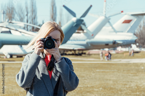 A female photographer is holding a camera.