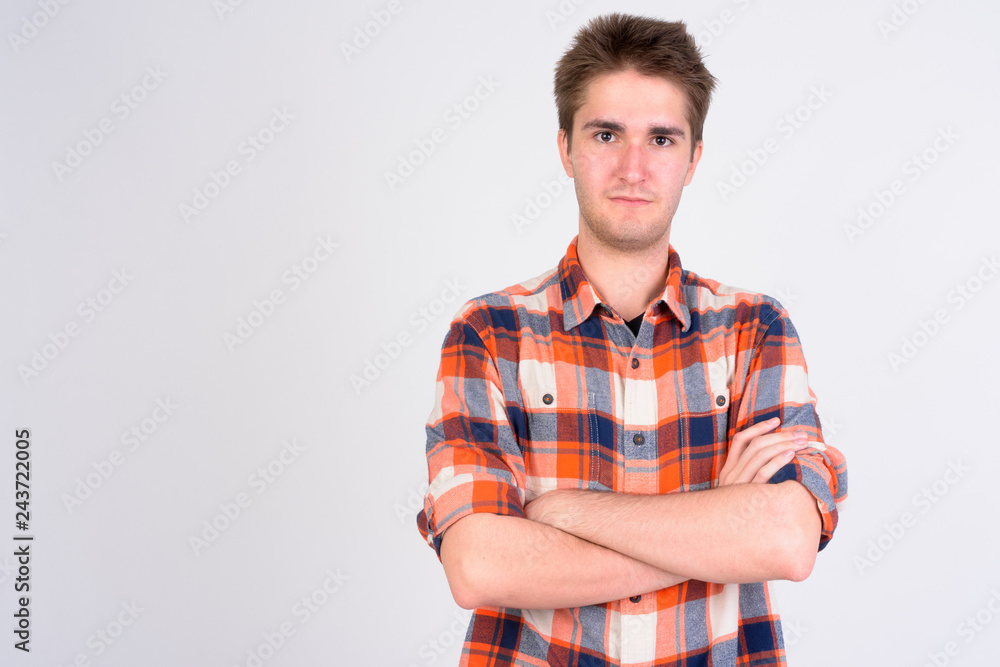 Young handsome man with arms crossed against white background Young handsome man with arms crossed against white background