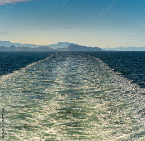 Foto Sunny bright panorama of turbulent ship wash in the vast ocean channel of Stephen's Passage, Alaska, USA Inside Passage