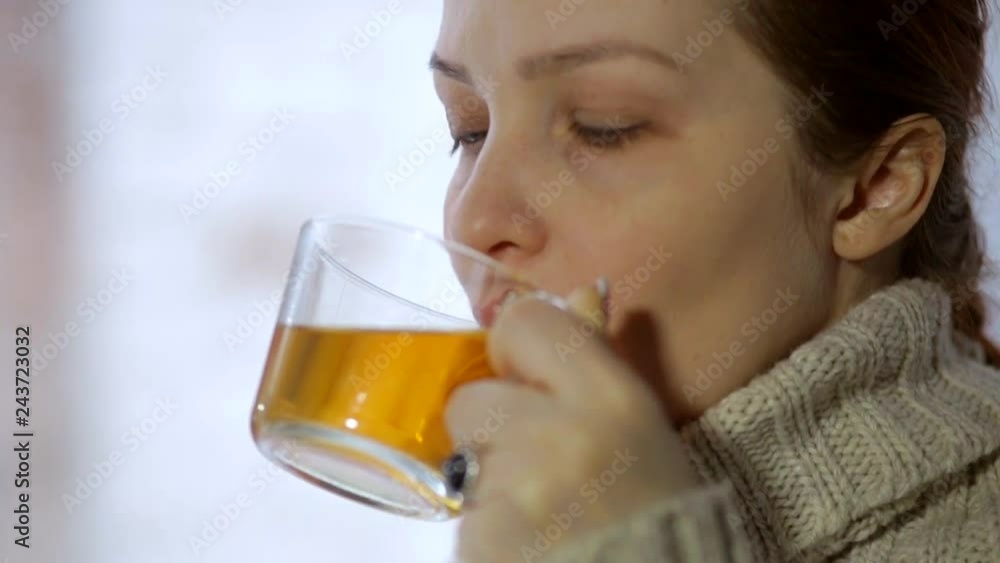 beautiful woman drinking tea in winter on the windowsill beautiful woman drinking tea in winter on the windowsill
