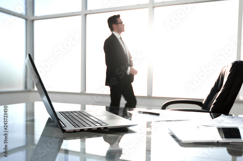 Businessman standing and looking out the window in the conference room