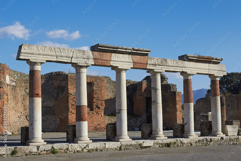 Arc with ruins around in ancient town of Pompei, Naples, Italy