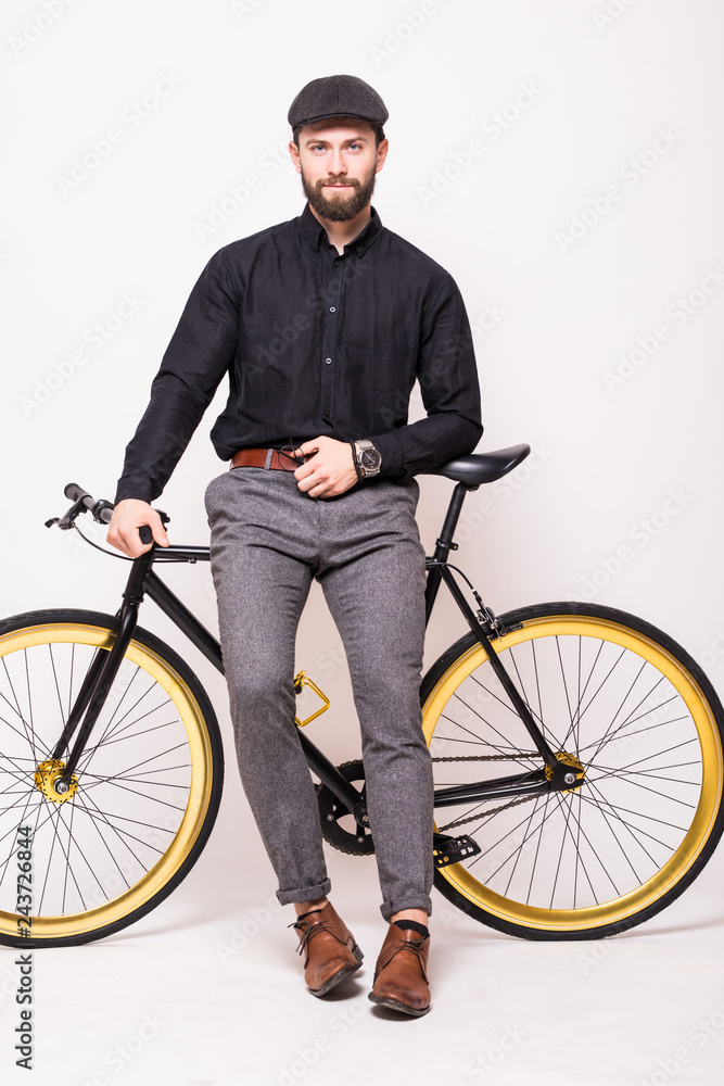 Young bearded hipster man leaning on fixie bicycle over white background Young bearded hipster man leaning on fixie bicycle over white background