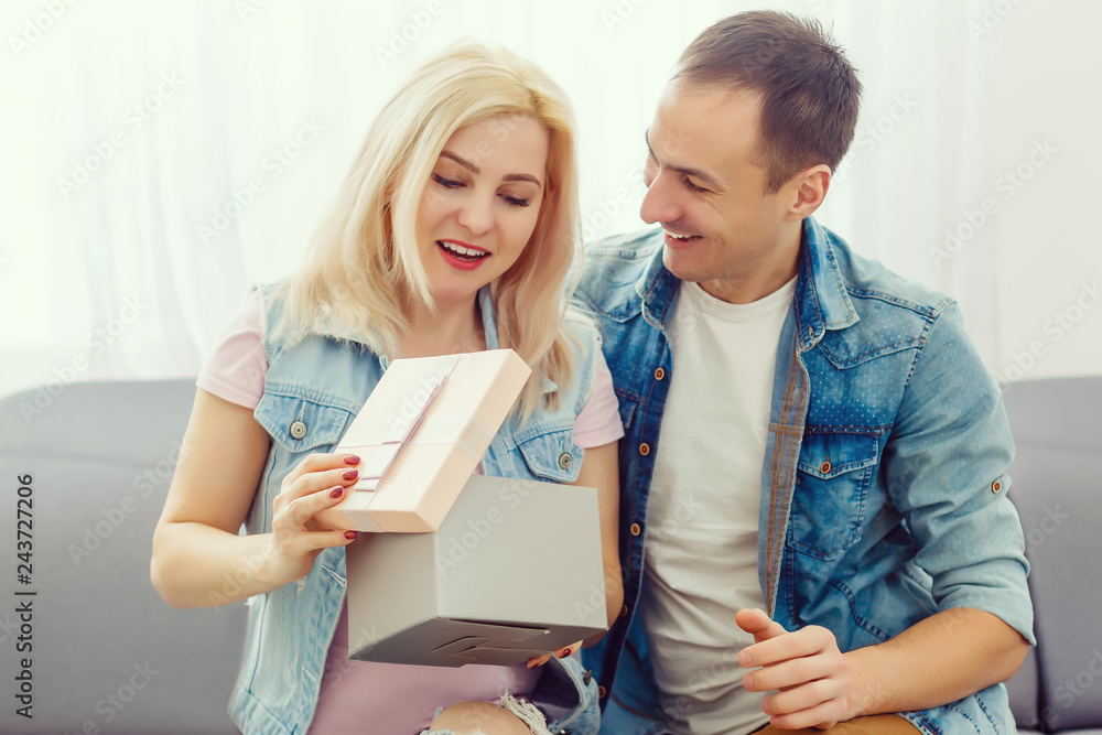 Love, holiday, celebration and family concept - smiling man surprises his girlfriend with present at home Love, holiday, celebration and family concept - smiling man surprises his girlfriend with present at home