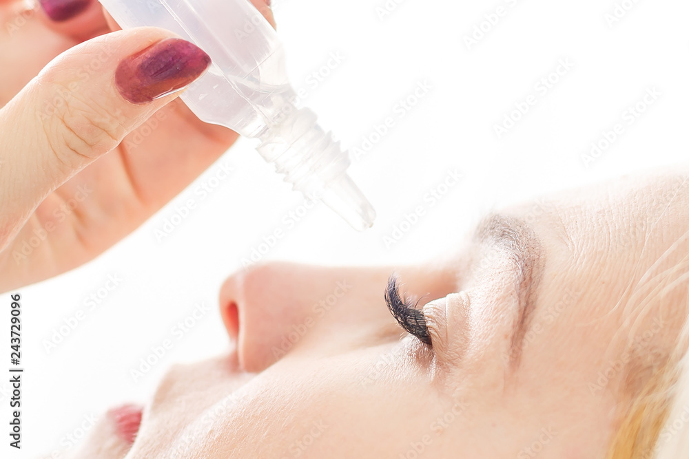 Close up of female face and eye drops Close up of female face and eye drops