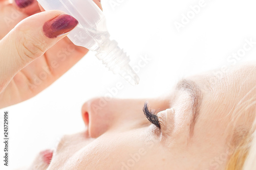 Close up of female face and eye drops photo