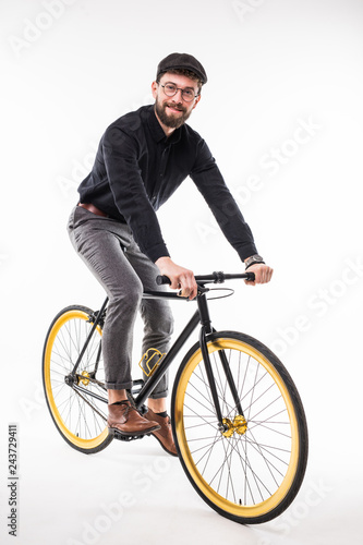 Portrait of a hipster beard man riding on bicycle over gray background