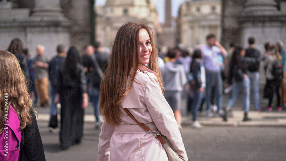 Amazing young girl walking in Rome and posing on camera. Prety woman on the background of crowd. Italian fashion,culture and way of life   