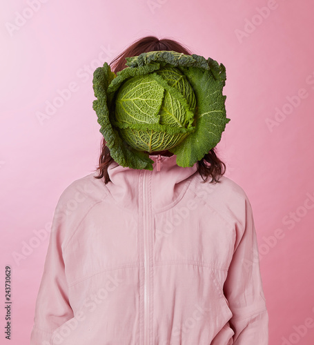 Woman's face covered with cabbage