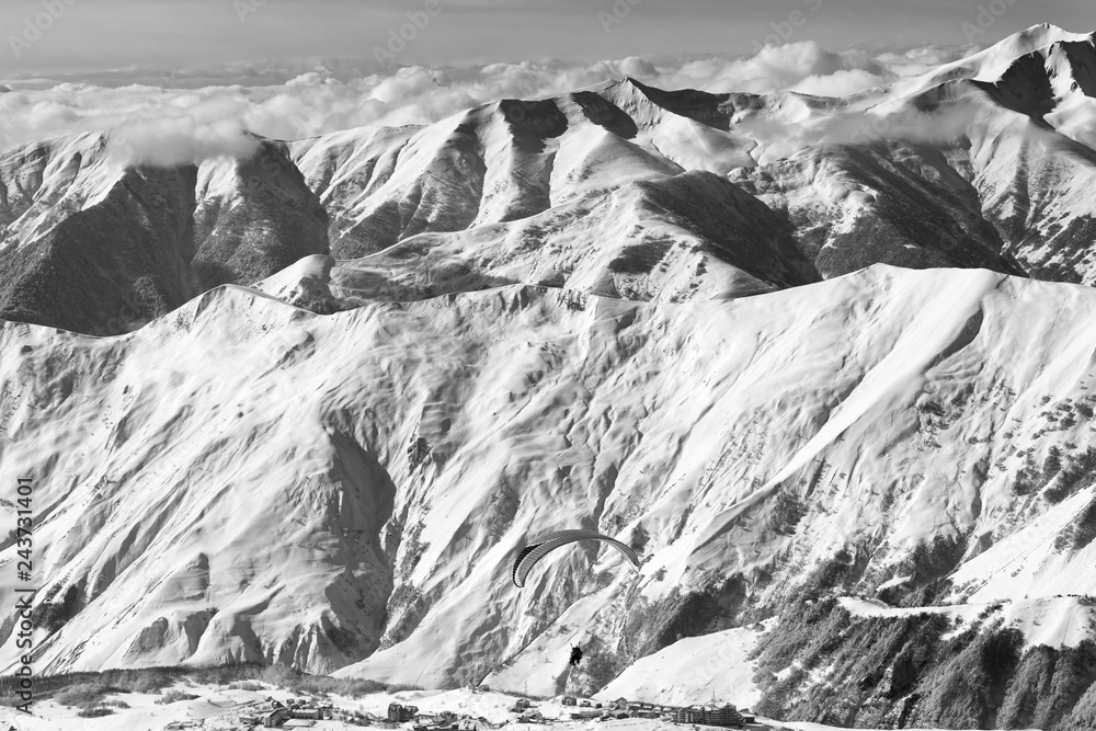 Obraz premium Speed flying at snowy mountains over ski resort at sunny winter day
