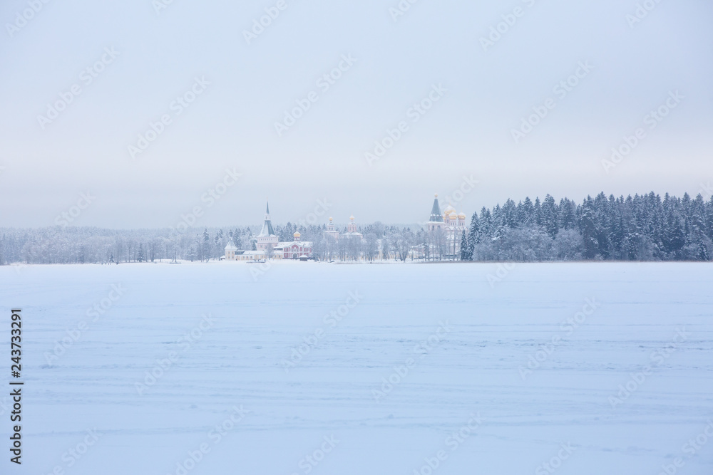 View on Orthodox church on another side of  the frozen lake. Church is lighted by sun