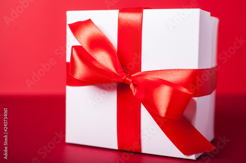 Gift box on red background. Valentine day, woman day gift. Red and white. ribbon, band.
