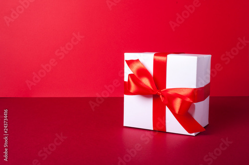 Gift box on red background. Valentine day, woman day gift. Red and white. ribbon, band.