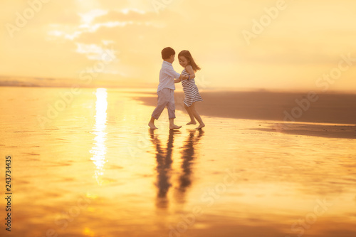 girl and boy dancing on the beach