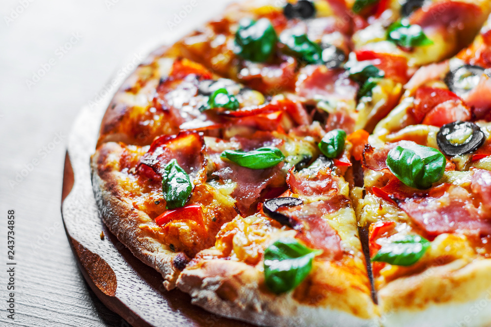 Pizza with Mozzarella cheese, ham, pepper, olive, meat, Tomato sauce, Spices and Fresh Basil. Italian pizza on wooden background Pizza with Mozzarella cheese, ham, pepper, olive, meat, Tomato sauce, Spices and Fresh Basil. Italian pizza on wooden background