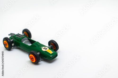Miniature green race car with number 3 isolated on a white background for on a three-year-old birthday cart