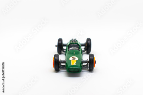 Miniature green race car with number 3 isolated on a white background for on a three-year-old birthday cart