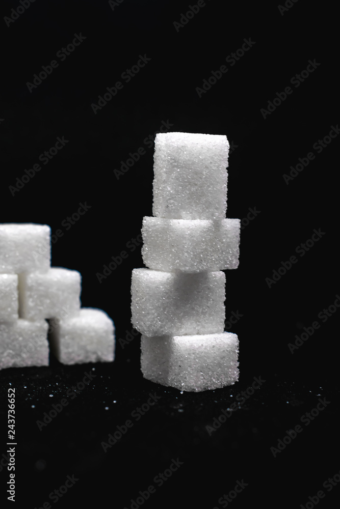 Tower built out of sugar white cubes on an isolated black background with blank space Tower built out of sugar white cubes on an isolated black background with blank space