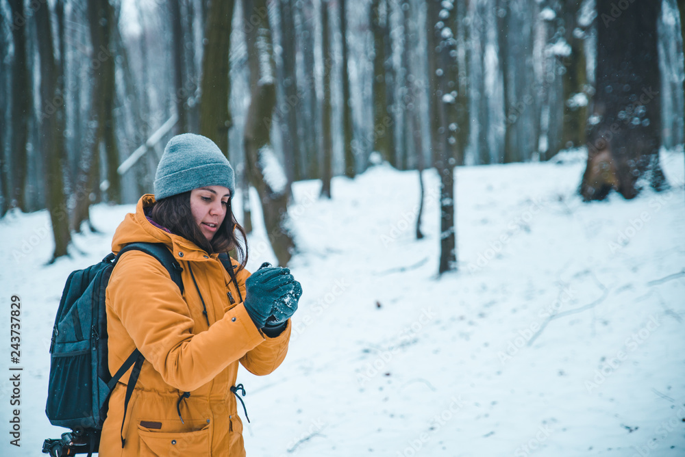 woman making snowball in snowed forest