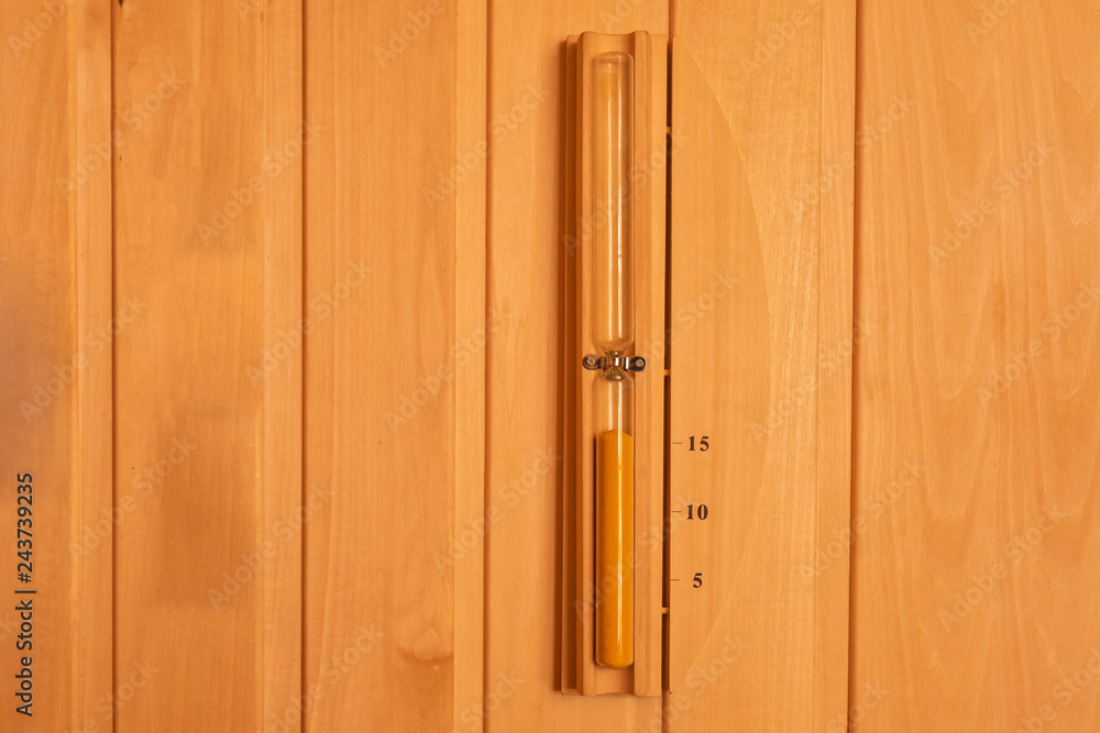 Hourglass hanged on wooden wall of sauna. Sandglass timer. Hourglass hanged on wooden wall of sauna. Sandglass timer.