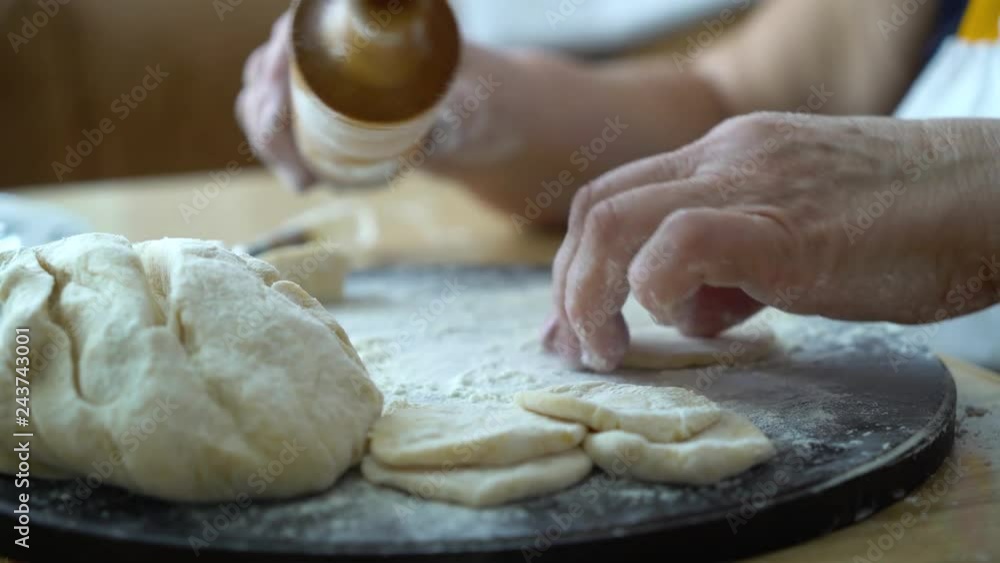 senior woman hands rolling pieces of dough with rolling pin closeup senior woman hands rolling pieces of dough with rolling pin closeup