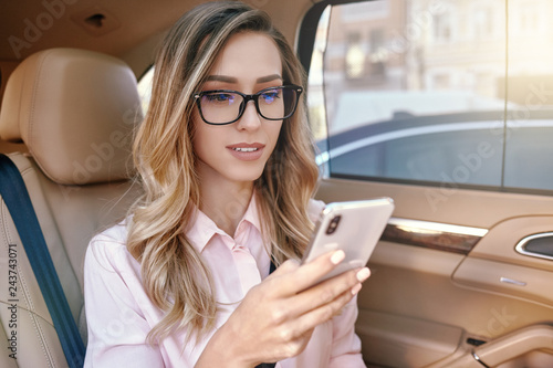 businesswoman using smartphone in the car