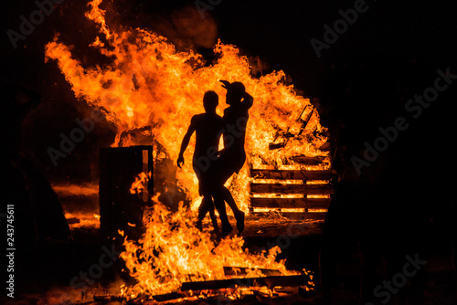 personas saltando en las  hogueras de la noche de San Juan  photo