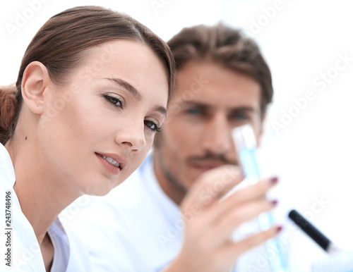 Woman looking at test tubes with colorful liquids