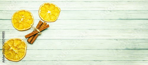 Top view, Orange slice and cinnamon sticks on a wood background, space for text