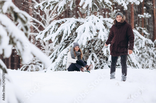 Beautiful couple on sledge having fun, winter snow day