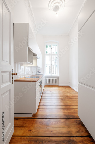 new white kitchenette / kitchen in renovated old building with wooden floor