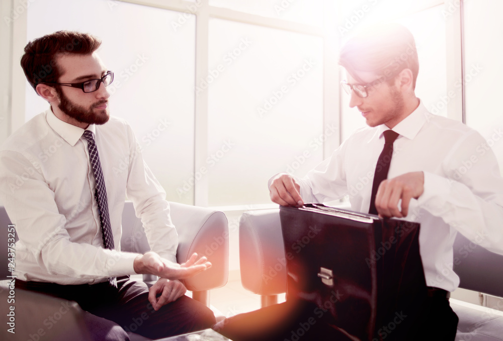 lawyer and businessman sitting in the lobby of the business center lawyer and businessman sitting in the lobby of the business center