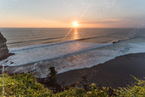 Beautiful ocean waves during sunset with lens flare photo