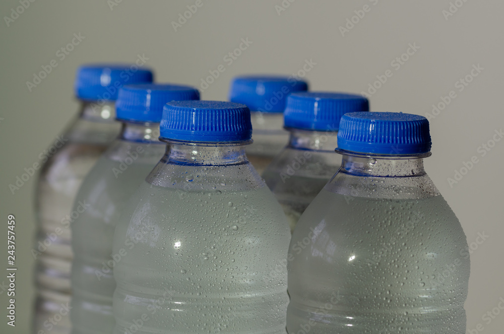 Plastic bottles of water on gray background. Plastic bottles of water on gray background.