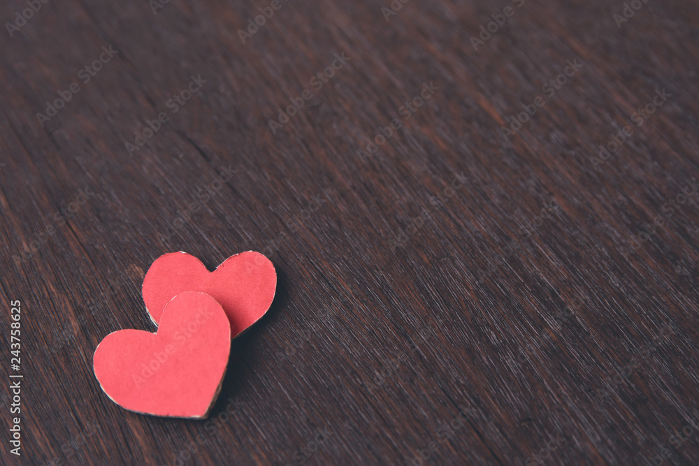 Obraz premium Valentines Day background with red heart shape on dark wooden background with copy space