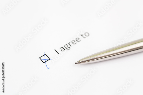 I agree to - checkbox with a check mark on white paper with pen. Checklist concept