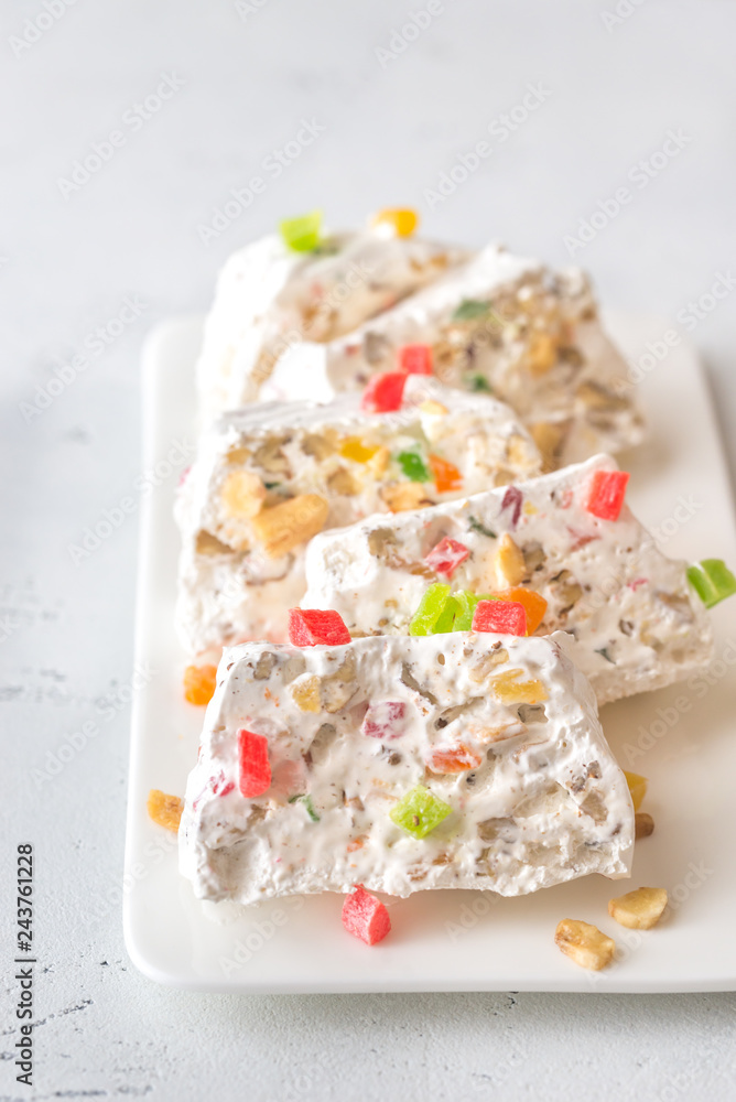 White nougat slices on white plate White nougat slices on white plate