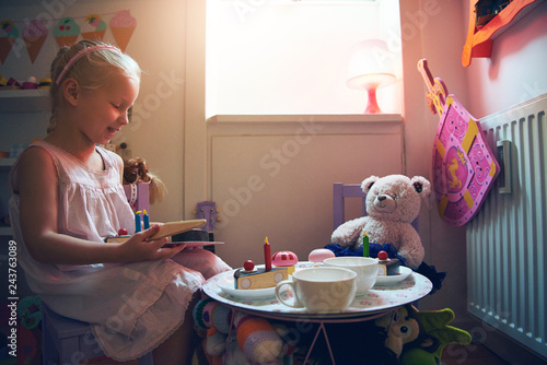 Schilderij op canvas Cute girl playing tea-party with her toys