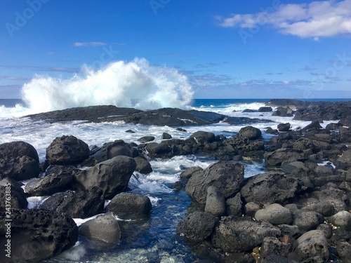 Waves crash into lava rock during high surf