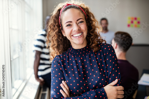 Smiling female designer standing in an modern office photo