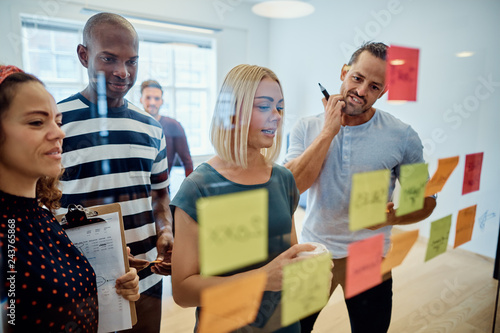 Designers brainstorming with sticky notes during an office meeti