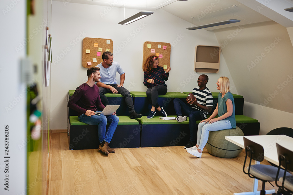 Laughing group of designers having a meeting in an office Laughing group of designers having a meeting in an office