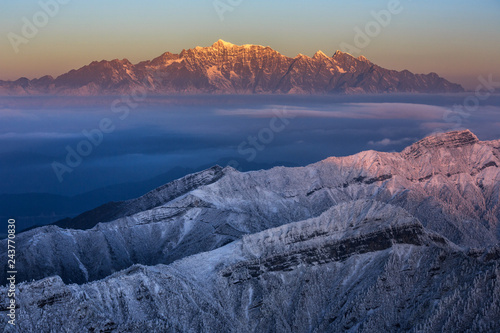 Dawn, Sunrise above the clouds - Niubeishan Landscape, Cattle Back Mountain, Sichuan Province China. Snow mountains, Ice Frost and Rime. Frozen Winter Landscape, Frigid Cold Atmosphere. Sea of Clouds photo