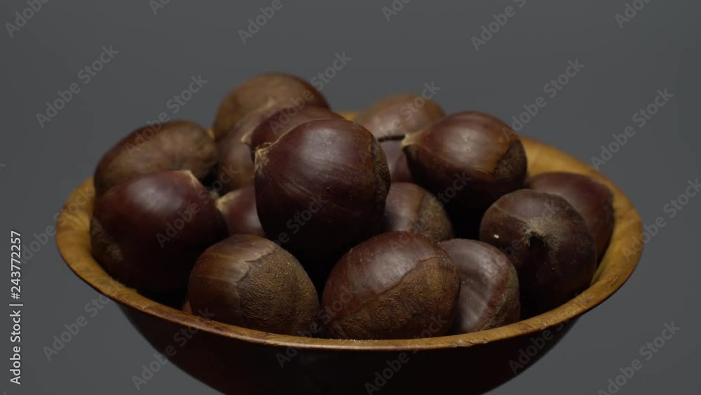 Chestnut. Close up. Heap of raw unroasted sweet chestnut in a bowl in rotation. Food background. gray background, studio shot. Healthy food diet concept. Gastronomy and organic food concept. Chestnut. Close up. Heap of raw unroasted sweet chestnut in a bowl in rotation. Food background. gray background, studio shot. Healthy food diet concept. Gastronomy and organic food concept.