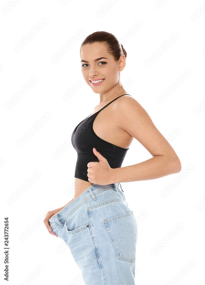 Slim woman in oversized jeans on white background. Weight loss Slim woman in oversized jeans on white background. Weight loss