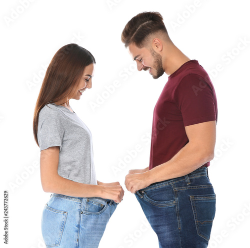 Fit people in oversized jeans on white background. Weight loss