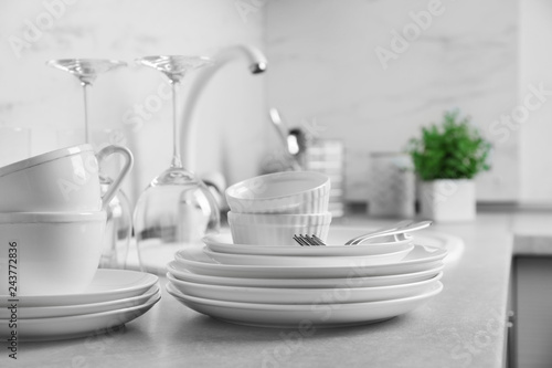 Set of clean dishes and cutlery on kitchen counter