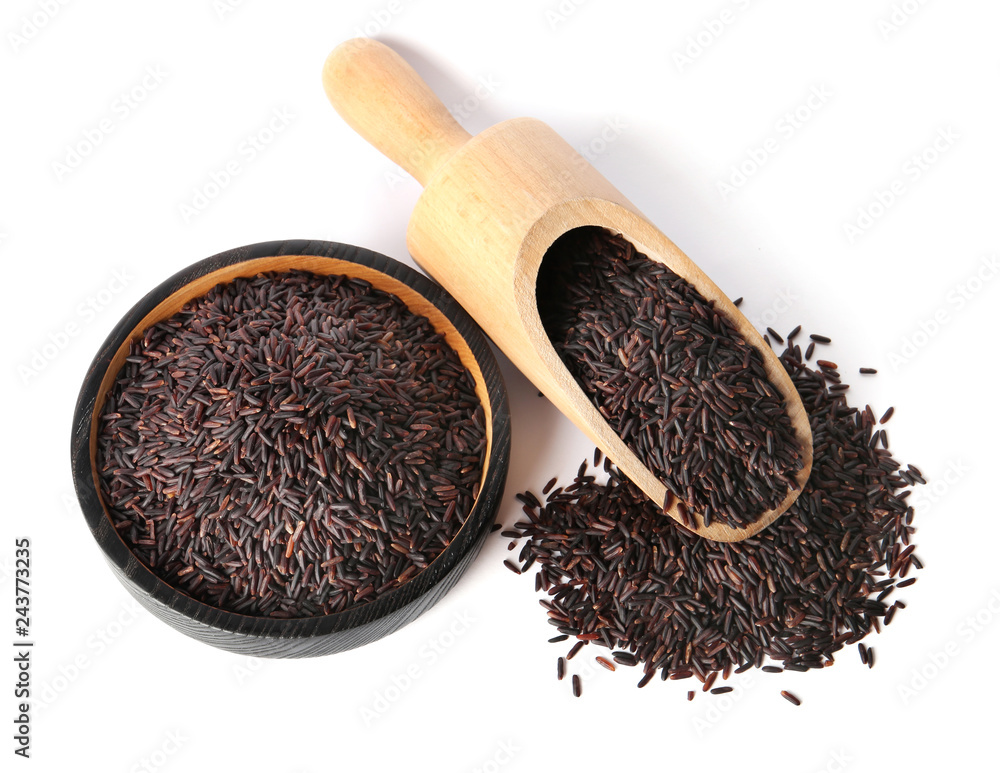 Plate and scoop with uncooked black rice on white background Plate and scoop with uncooked black rice on white background