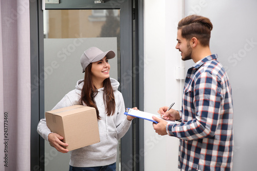 Man receiving parcel from delivery service courier indoors