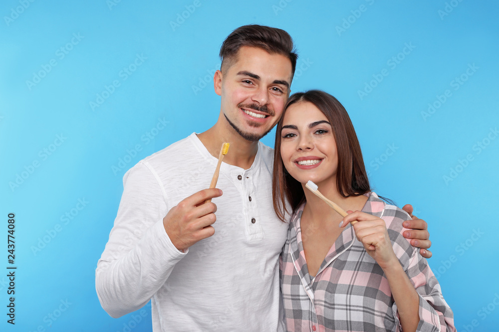 Happy couple brushing teeth on color background Happy couple brushing teeth on color background